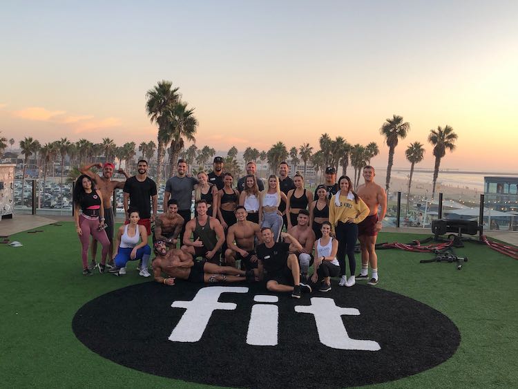 image of a group of fit people behind a mat on the ground that says fit